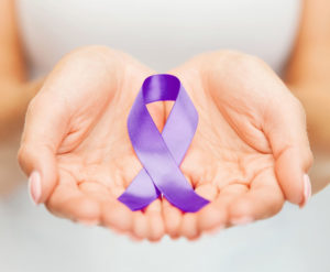 Picture of two hands holding looped purple ribbon 