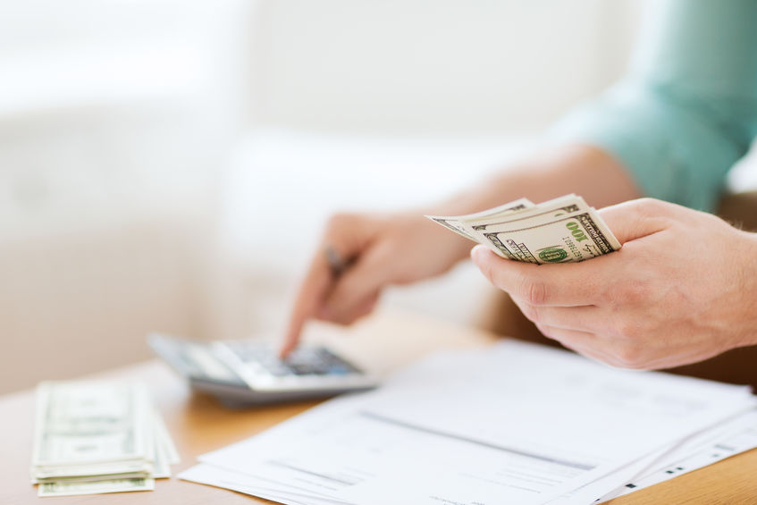 Picture of woman counting cash and using a calculator