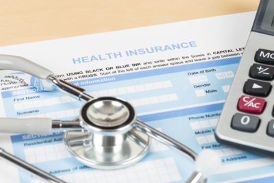 Picture of health insurance application, stethoscope and calculator