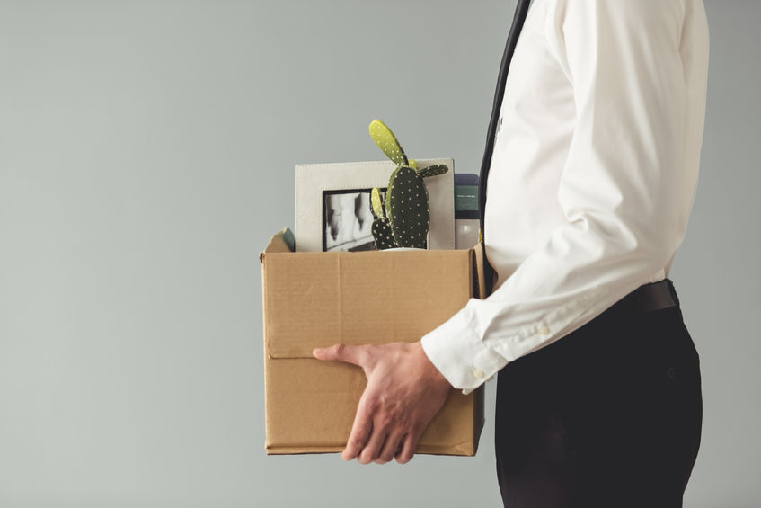 Picture of fired man with a box of stuff from his office