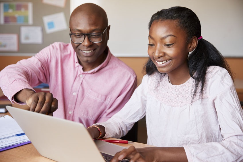 Picture of father and daughter at home online schooling with laptop