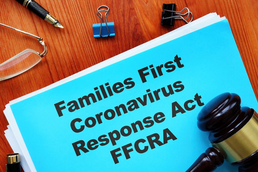 Picture of document with Families First Coronoavirus Response Act FFCRA under gavel on desk with pair of glasses, pen, and 2 binder clips