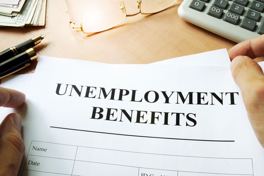 Picture of unemployment benefit form on desk next to a pair of glasses