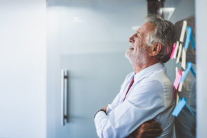 Old man leaning against the wall at his office after being suffering RETALIATION