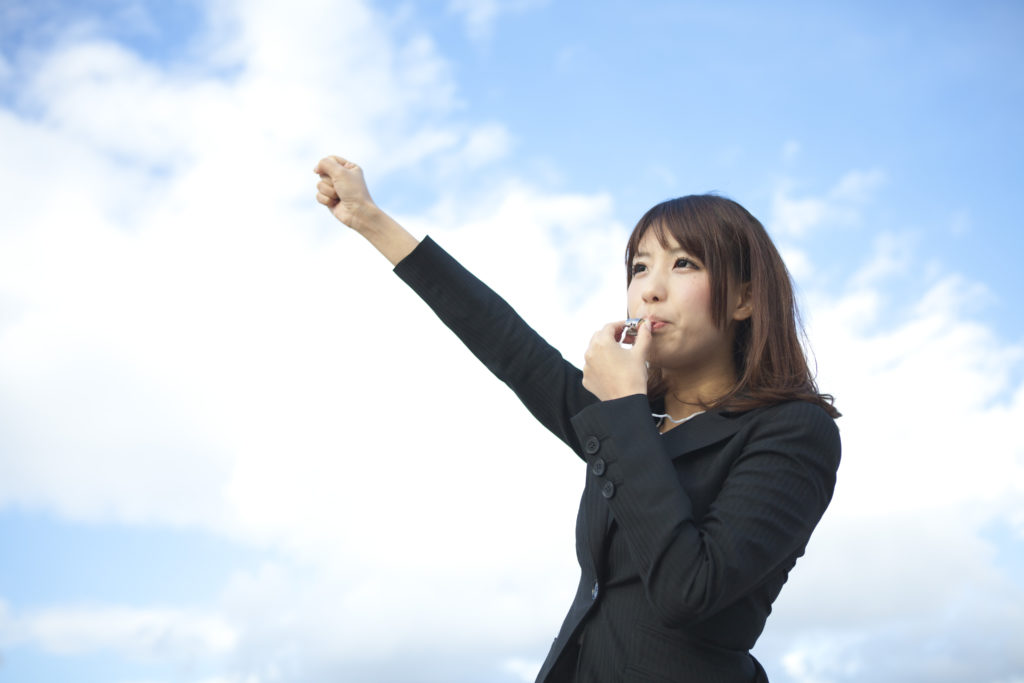 Pix of Woman blowing the whistle with arm raised in the sky WHISTLEBLOWER