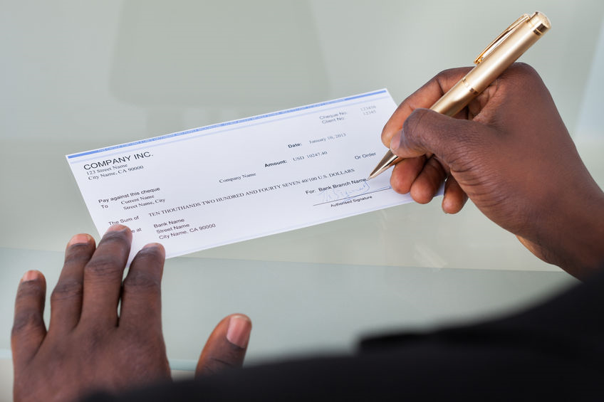 Picture of paycheck being written on desk top