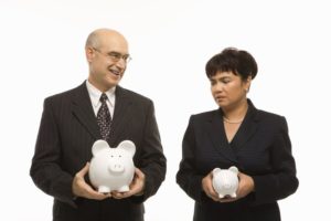 Picture of a man in a suit holding a large piggy bank next to a woman in a suit holding a much small piggy bank Equal Pay Claims