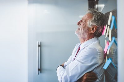 Old man leaning against the wall at his office after being suffering RETALIATION